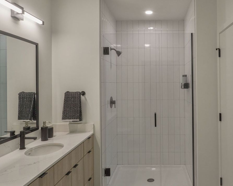 Bathrooms with expansive vanity space and showers with subway tile